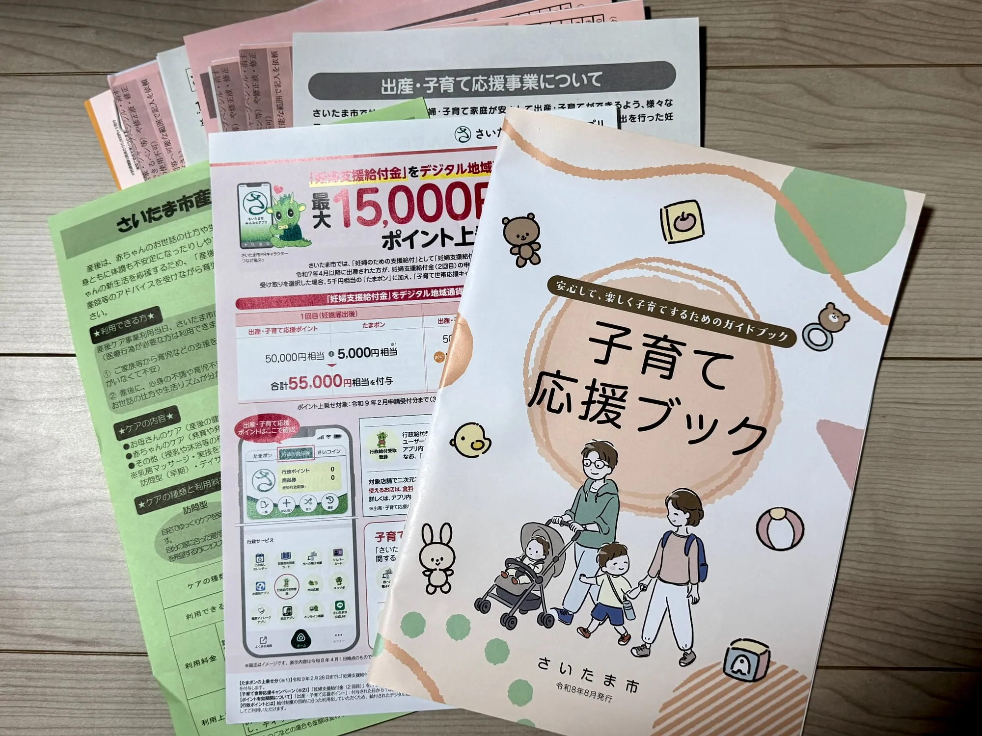 妊娠届を出したときに受け取った、さいたま市の子育て応援ブックや給付金・産後ケアの案内を並べた写真